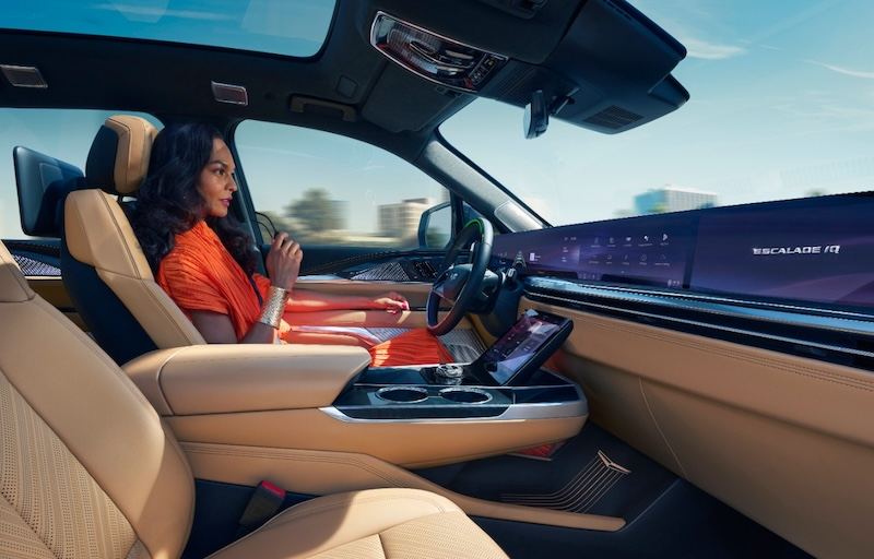 Una mujer conduce el Cadillac ESCALADE IQ con Super Cruise con pantalla de columna a columna a la vist